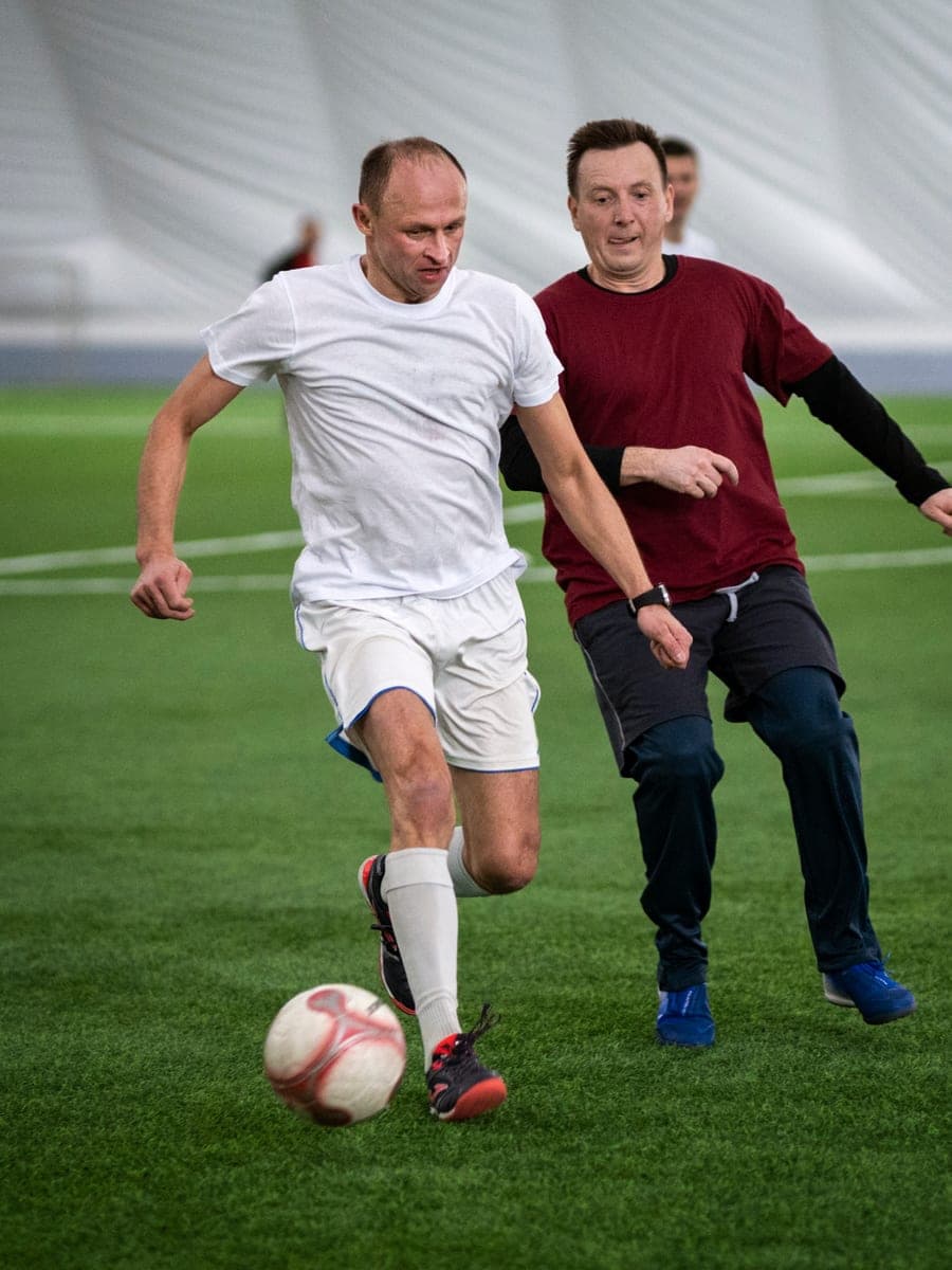Campo de futebol society com grama sintética durante uma partida