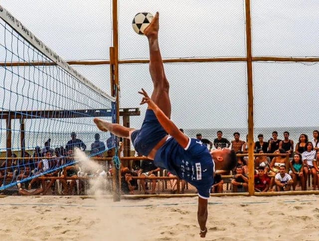 Atleta em movimento durante uma partida na areia